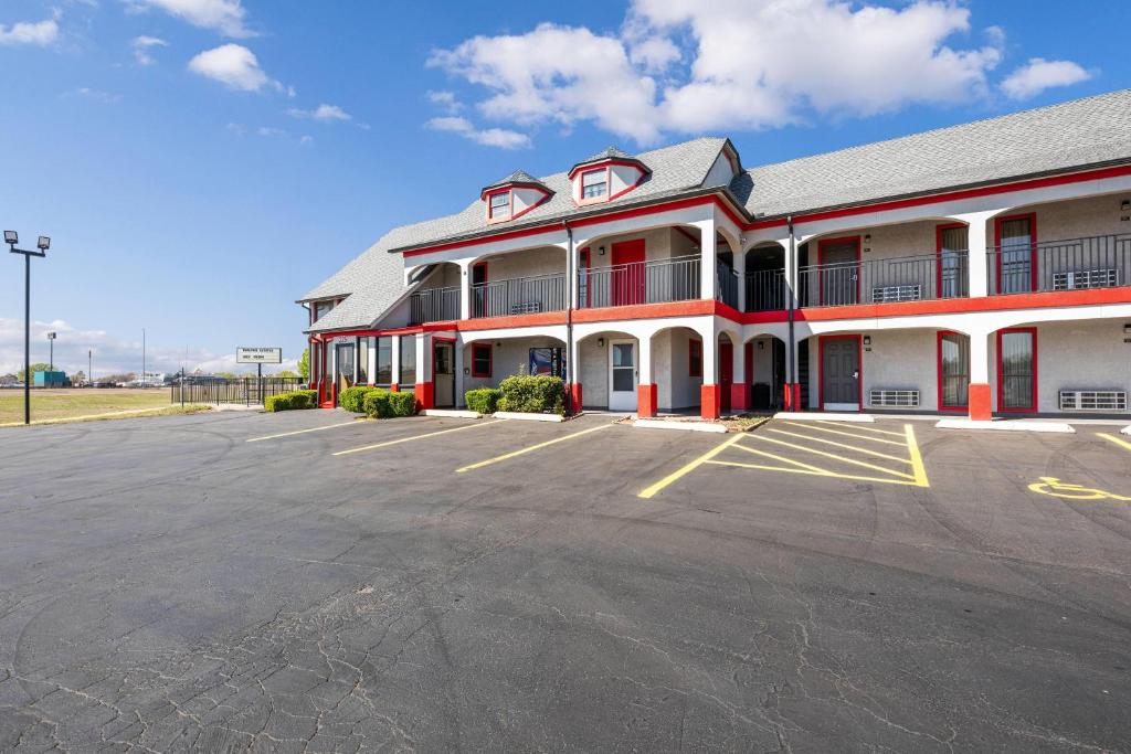 a building with a parking lot in front of it at Super 8 by Wyndham Norman West OK in Norman
