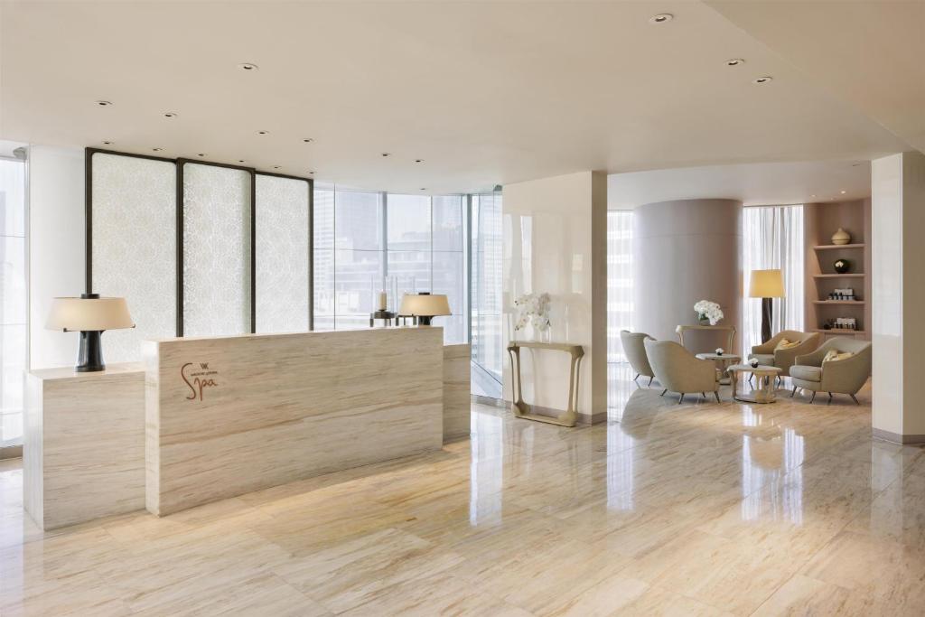 A bright reception lobby with a marble-look desk and lounge seating.
