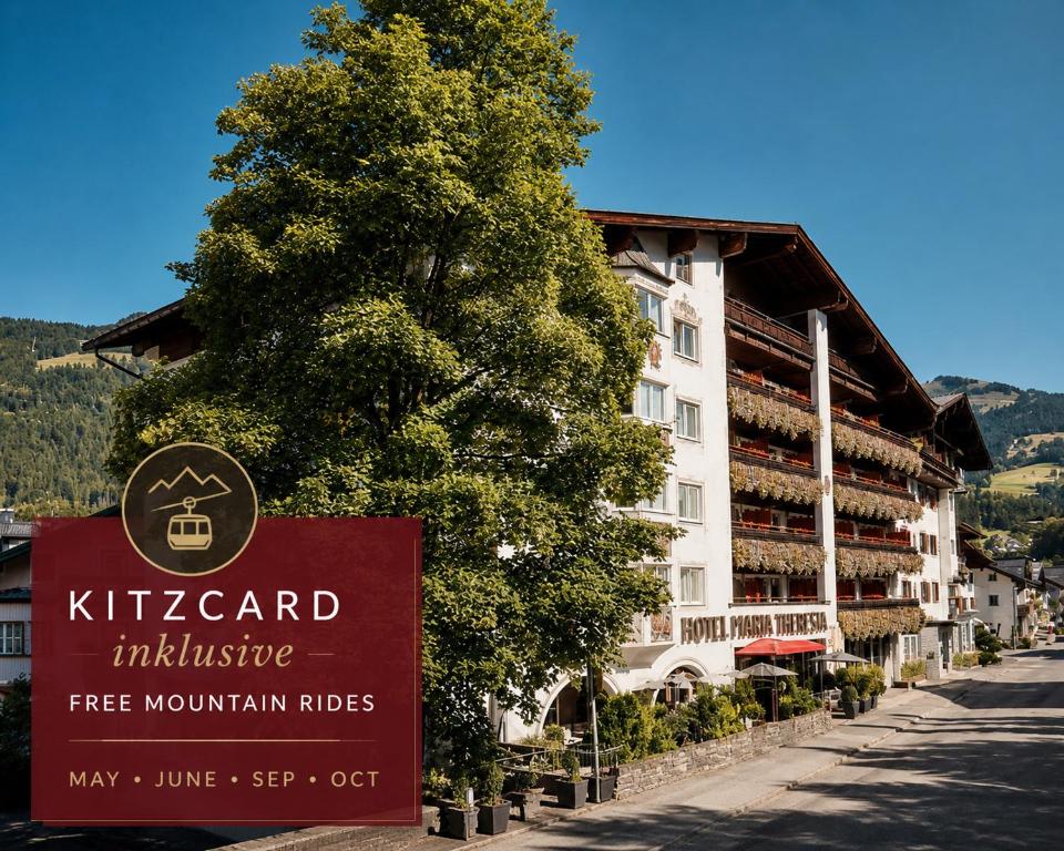a sign in front of a building with a tree at Q! Hotel Maria Theresia in Kitzbühel
