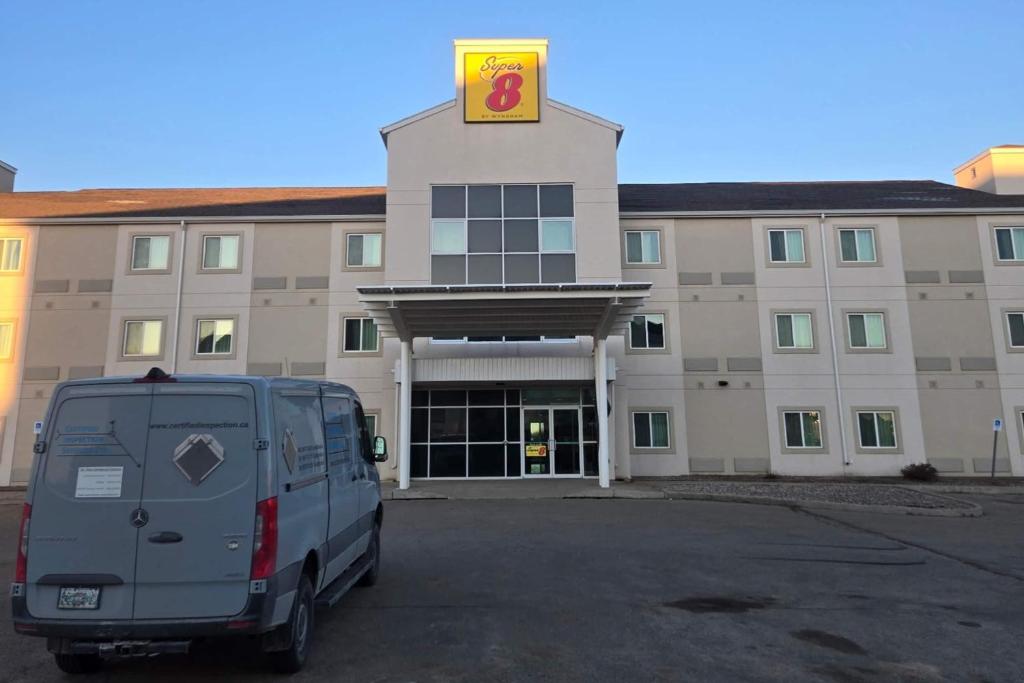a van parked in a parking lot in front of a building at Super 8 by Wyndham Estevan in Estevan