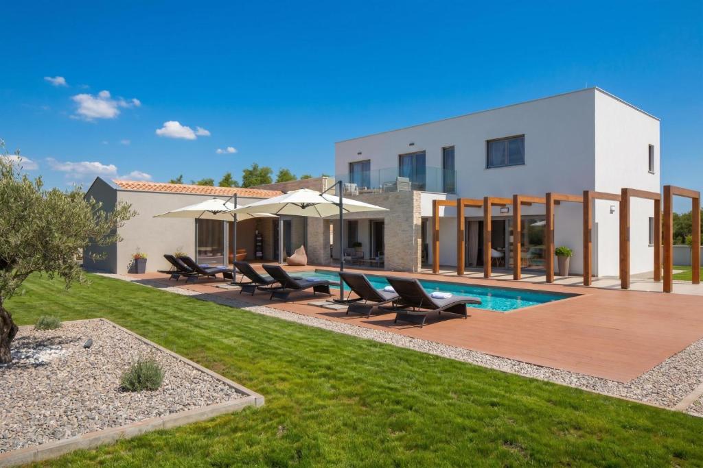 a villa with a swimming pool and a house at Villa Royal Green - Happy Rentals in Labin