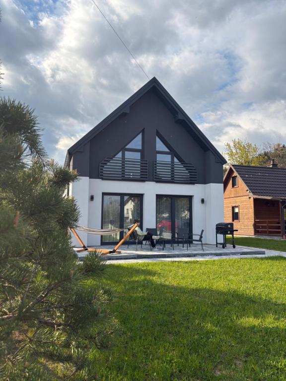 a black and white house with a yard at Na Pańskim in Klimkówka