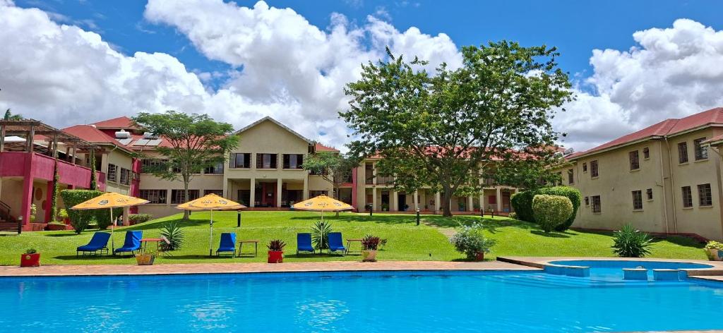 a pool with chairs and umbrellas at a resort at Red Chilli Hideaway in Kampala
