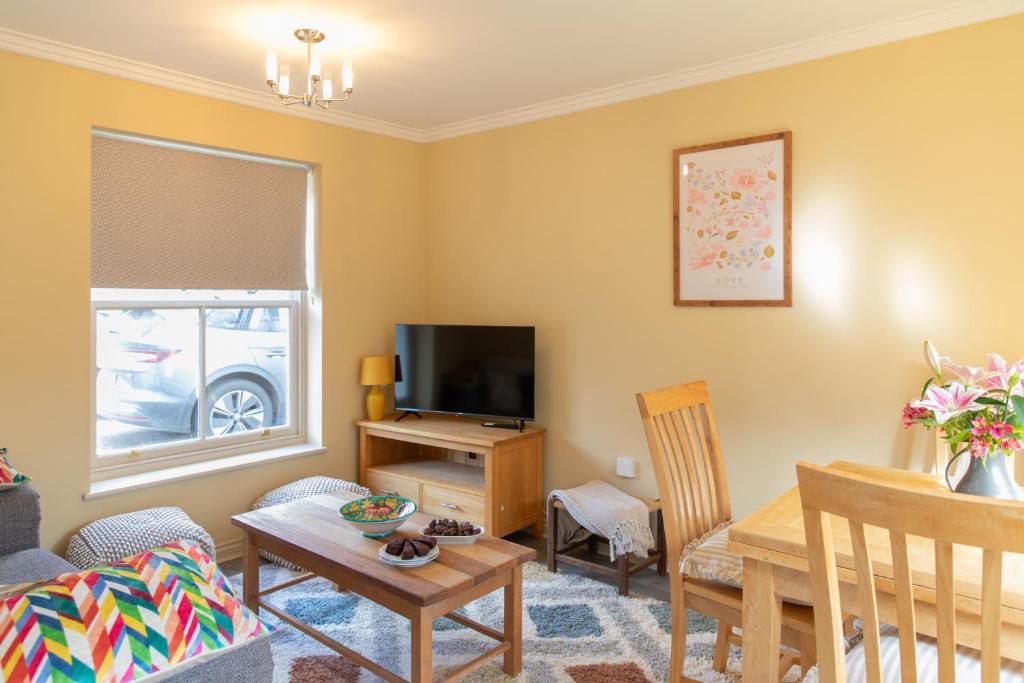 a living room with a table and a tv at Sheriff's Tower Cottage - West in Bishop Auckland