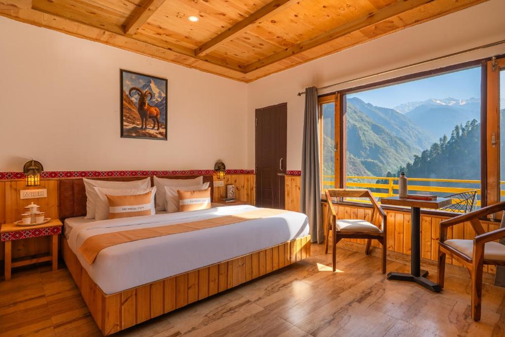 a bedroom with a bed and a large window at The Social Stays Tirthan in Bandal