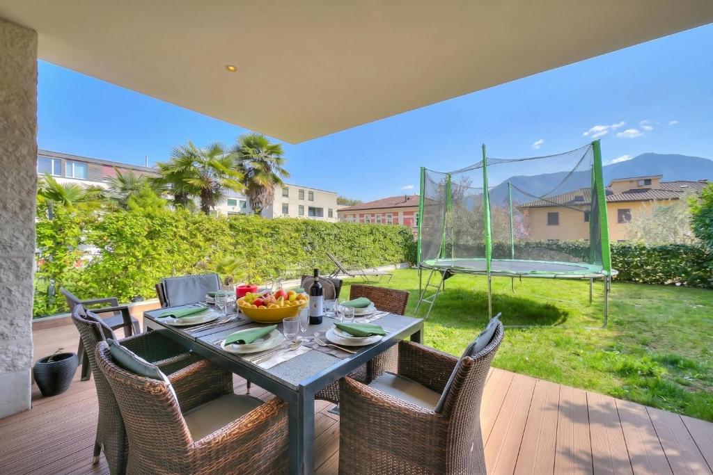 a table and chairs on a patio with a trampoline at Rebecca Garden with Terrace in Paradiso - Happy Rentals in Lugano