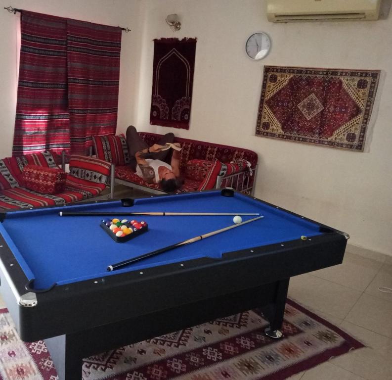 a pool table in a living room with a pool table at Heritage Hostel Muscat in Muscat