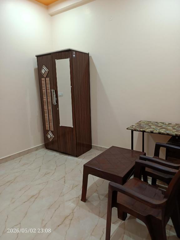 a room with a wooden cabinet and a table and chairs at Kedarnath villa in Kakarmatha