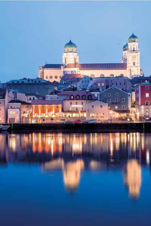 a group of buildings sitting next to a body of water at Blauer Bock in Passau