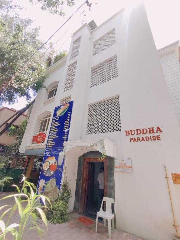 a white building with a sign that reads buffalo paradise at Narayan Guest House in Pune