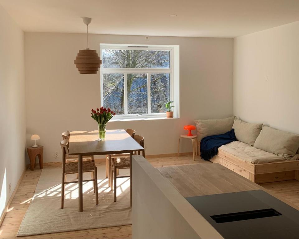 a living room with a table and a couch at Cozy Scandinavian design apartment in Bergen