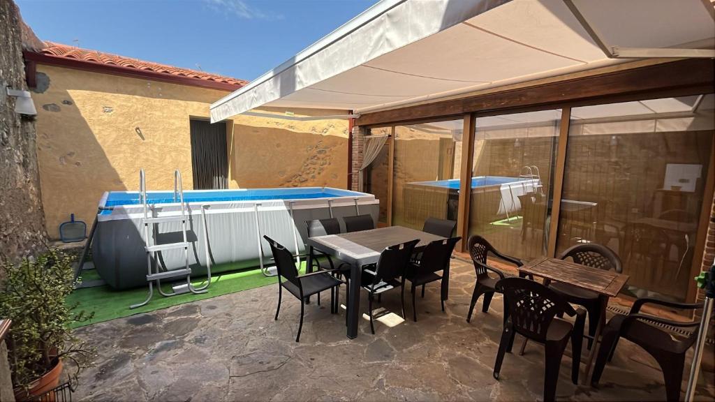 a patio with a table and chairs and a swimming pool at Hauzify I Casa Rourell in El Morell