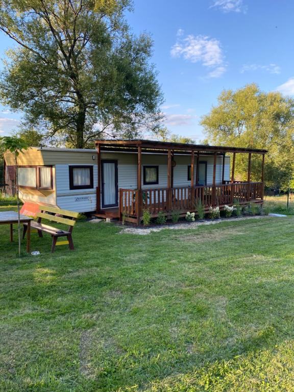 a tiny house with a porch and a picnic table at Marcyzakątek in Marcyporęba