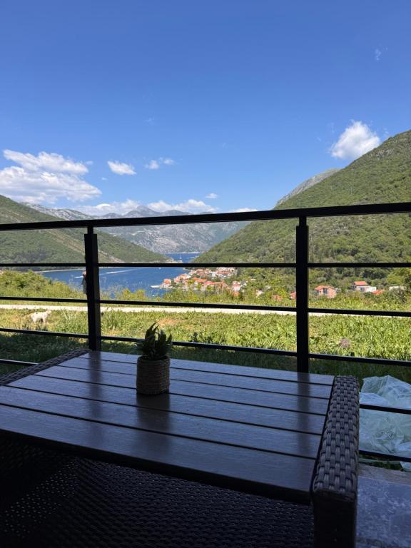 a table on a balcony with a view of a mountain at Hil's Bay View - Terra in Lepetani