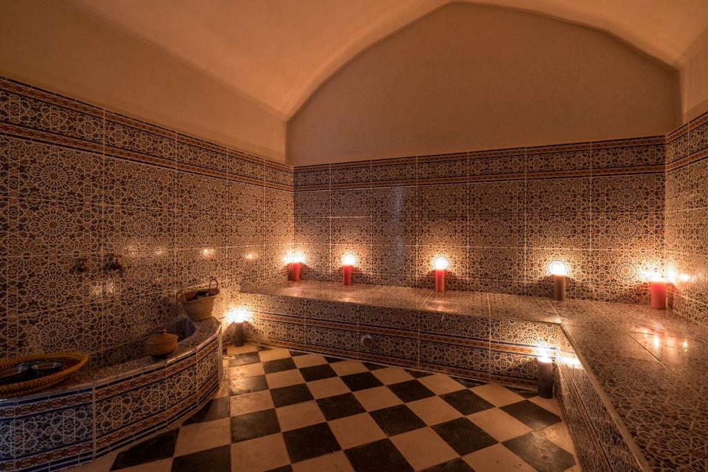 a bathroom with a tub and a checkered floor at Le Nid d'Aigle in Mirleft