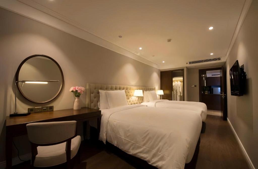 a hotel room with two beds and a mirror at Bow Luxury 3 in Danang