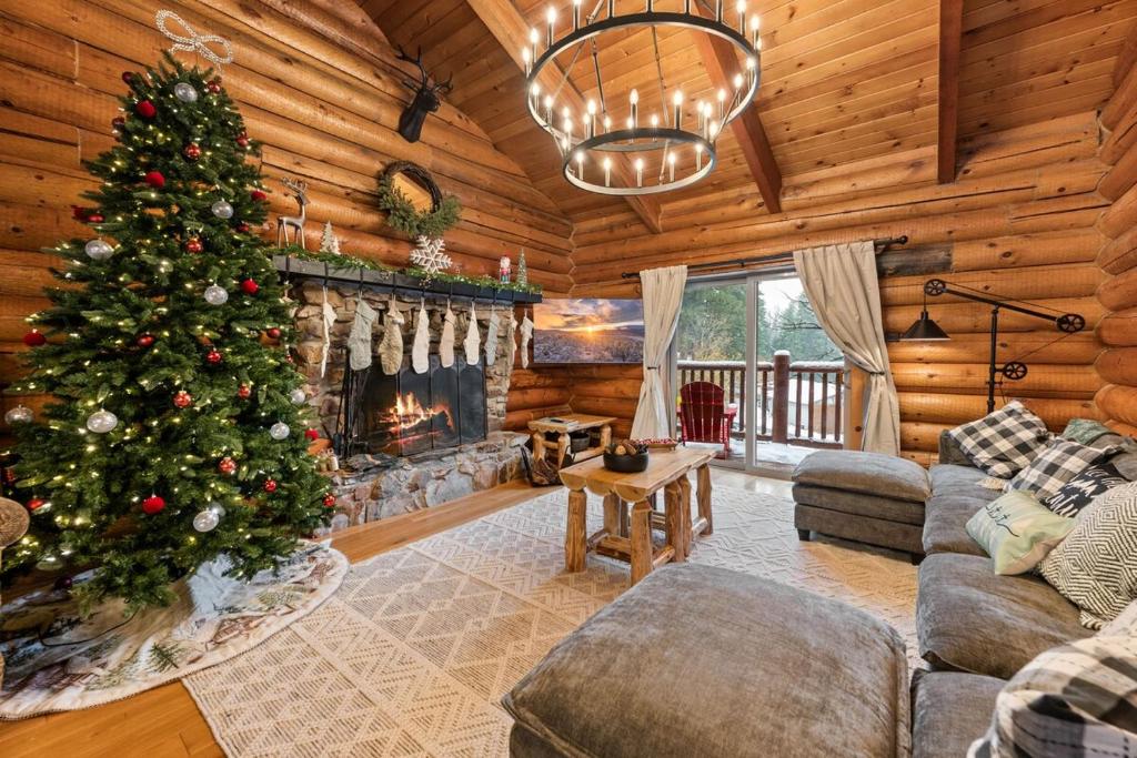 a christmas tree in a living room with a fireplace at Modern Log Home-Walk2Slopes&Trails-Spa-Arcade-EVch in Big Bear Lake
