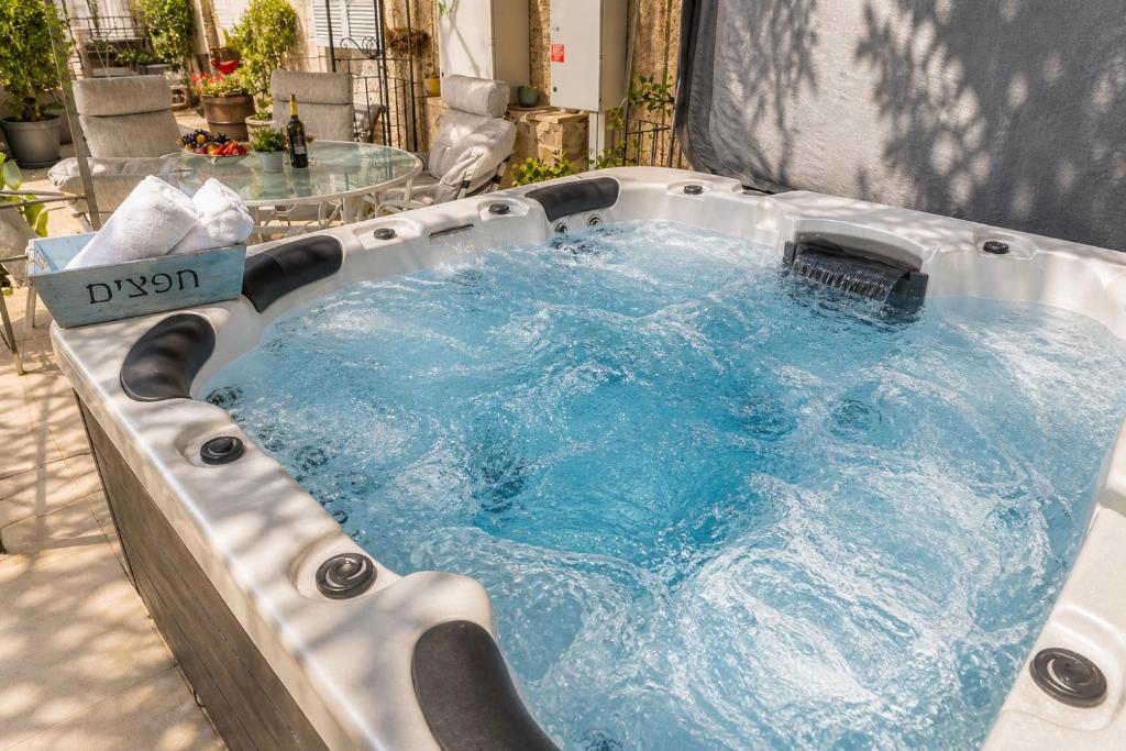 a jacuzzi hot tub with a table in it at המקום של ברקו in Me‘ona