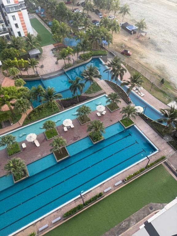 an overhead view of a pool with chairs and palm trees at Ecosea Timurbay in Kampong Tanjong