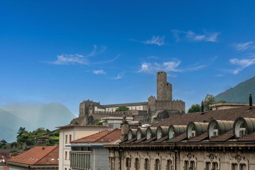 a castle in the background with buildings and roofs at Bellinzona Center in Bellinzona