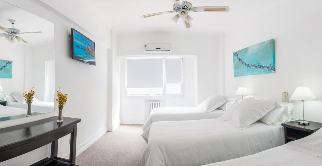 ein weißes Schlafzimmer mit 2 Betten und einem Deckenventilator in der Unterkunft Hotel Corbel Superior in Mar del Plata
