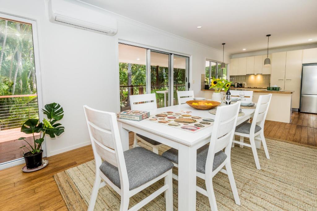 a kitchen and dining room with a white table and chairs at 10 Beach Houses in Agnes Water