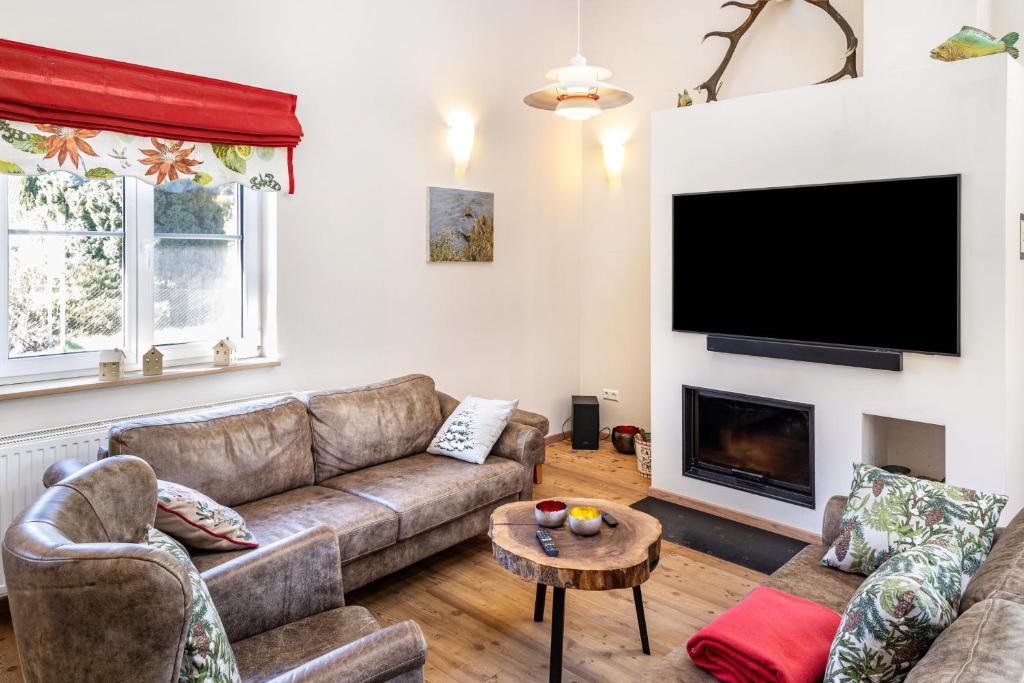 a living room with a couch and a flat screen tv at Ferienhaus Haussee in Himmelpfort