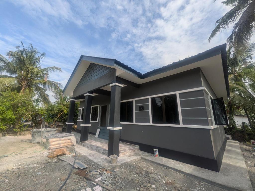 a house being constructed with a blue roof at Shareen Homestay Morib in Banting