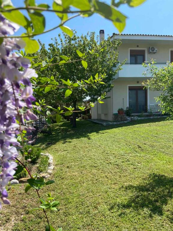a house with a yard with purple flowers at Zeusplace Lemon Villa in Korinos