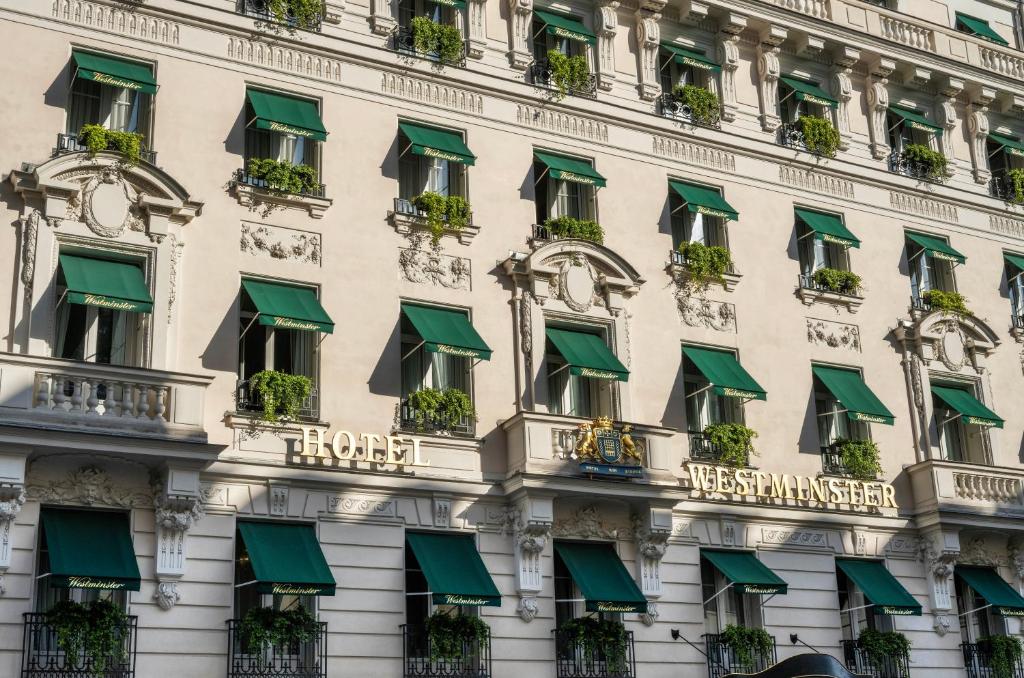 a facade of a building with green awnings at Hotel Westminster in Paris