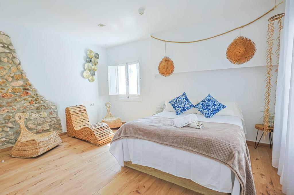a bedroom with a bed with blue pillows on it at Blancos Rooms Hotel in Peniscola