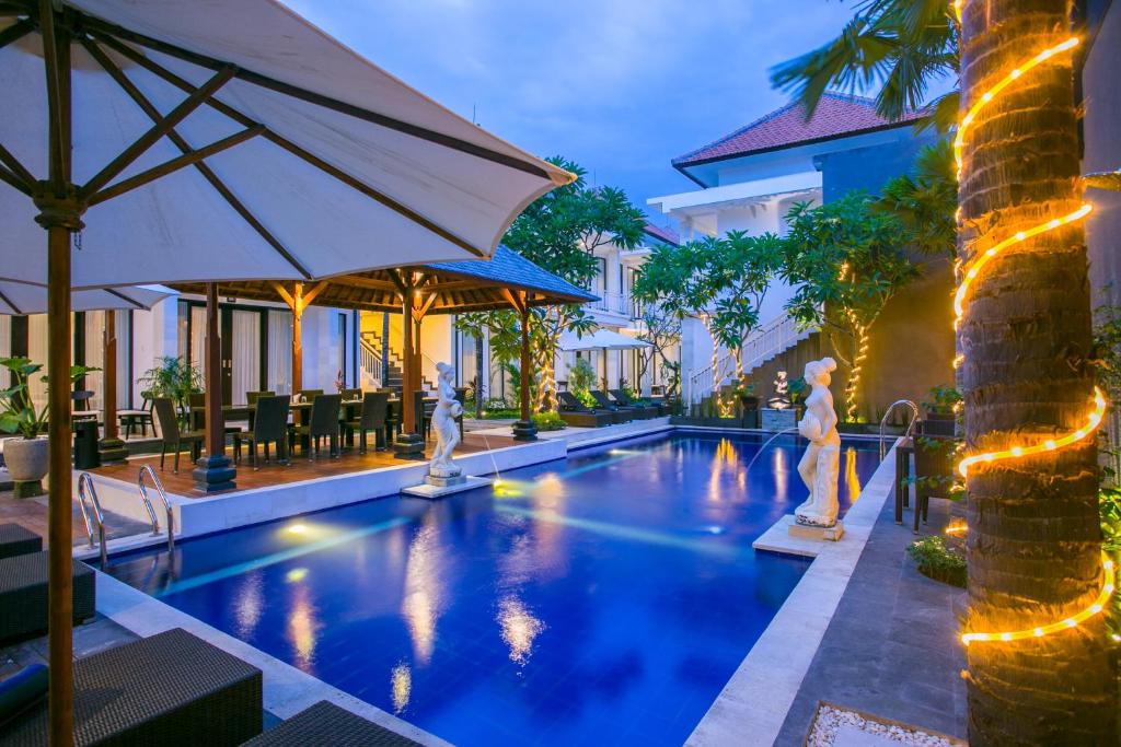 una piscina in un resort con due persone in piedi in acqua di The Diana Suite a Kuta