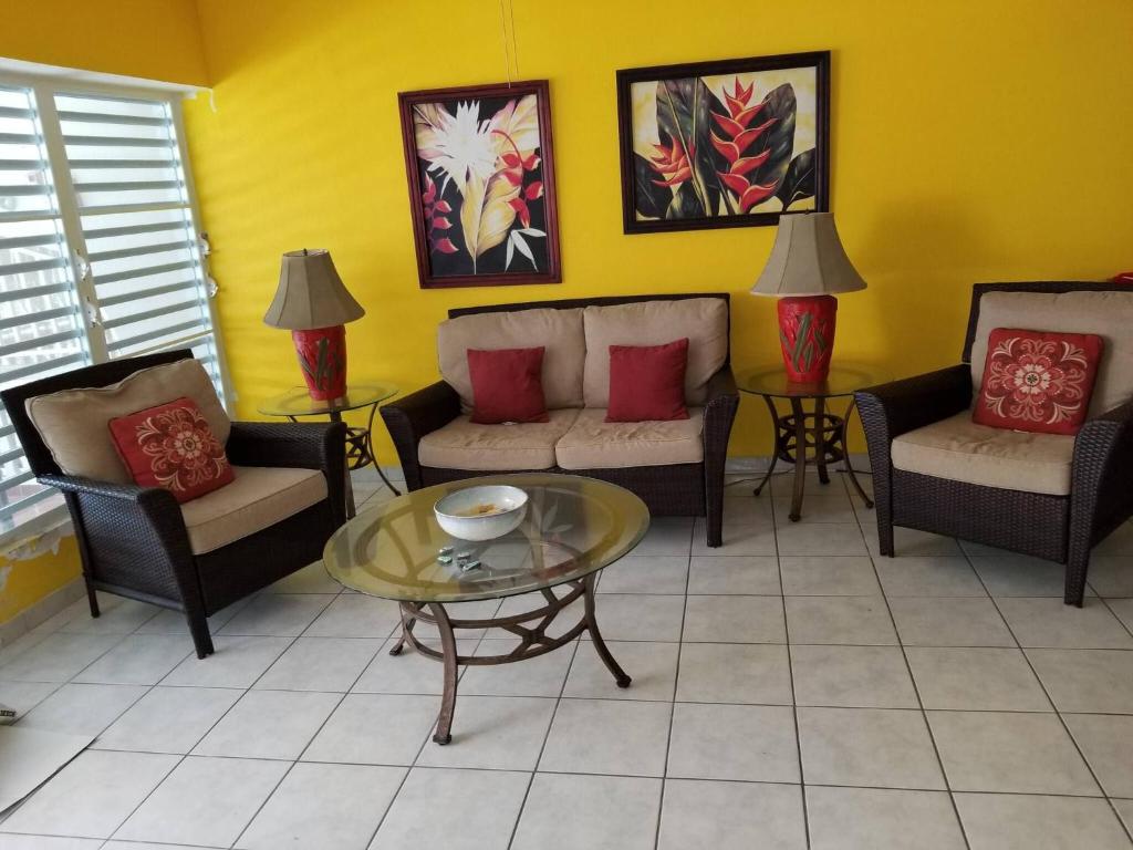 a living room with chairs and a coffee table at Charming 3-Bedroom House Steps from Luquillo Beach in Luquillo