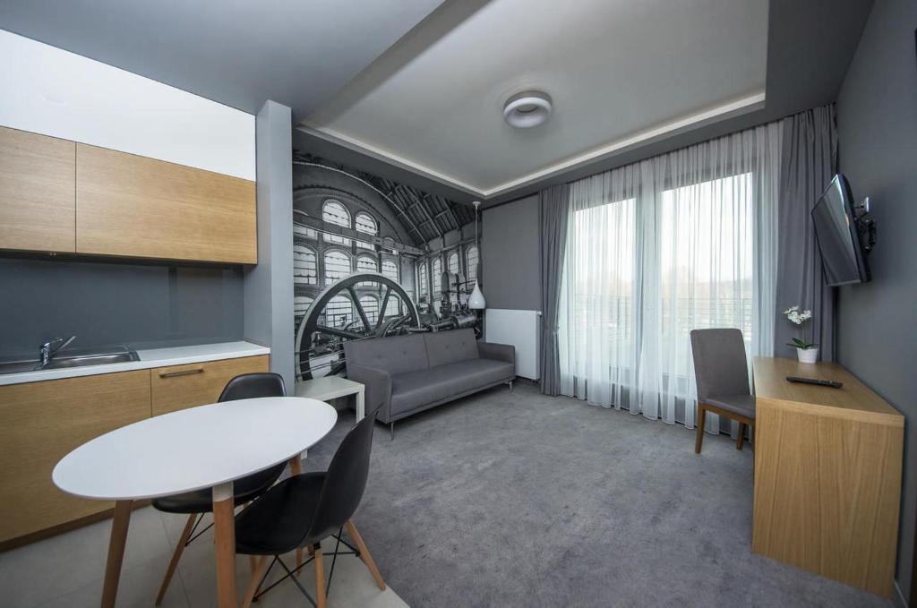eine Küche und ein Wohnzimmer mit einem Tisch und Stühlen in der Unterkunft Apartamenty D20 in Rybnik