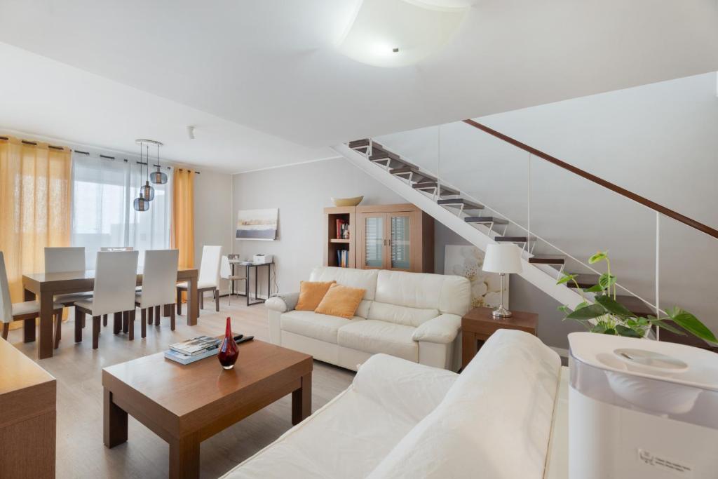 a living room with a white couch and a staircase at Casa Vistahermosa in Chayofa