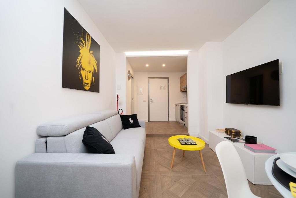 a living room with a white couch and a tv at Seven Thousand Apartment in Brescia