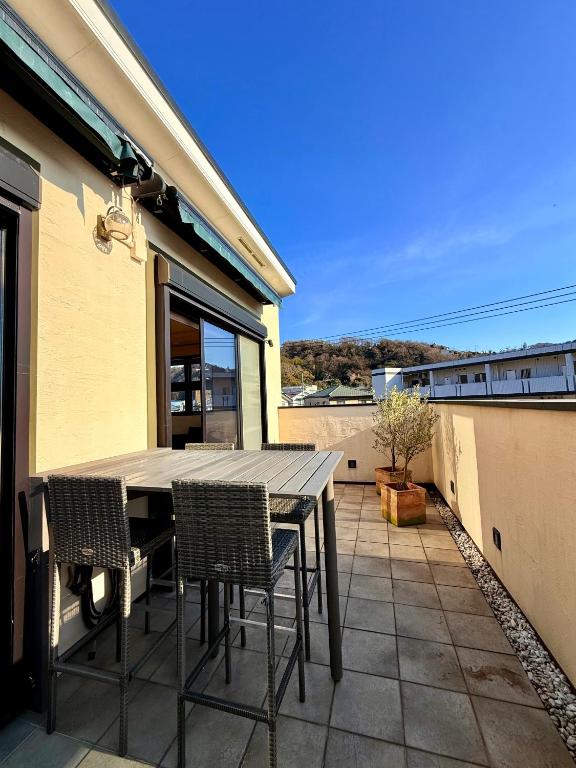 a table and chairs on the balcony of a house at Cielito Hayama 最大10名 海まで10分 テラスBBQ 葉山の空と海と富士山に出会うヴィラ in Hayama