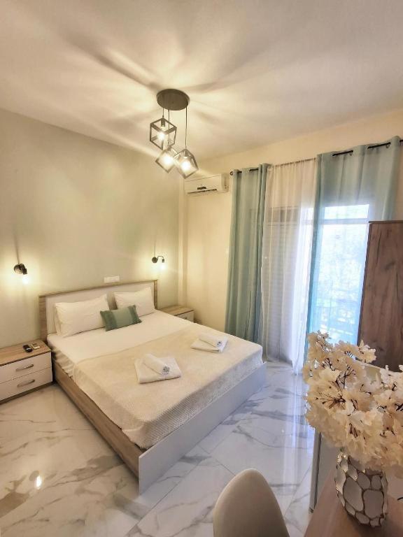 a bedroom with a large white bed and a window at Foteini Rooms in Skala Sotiros