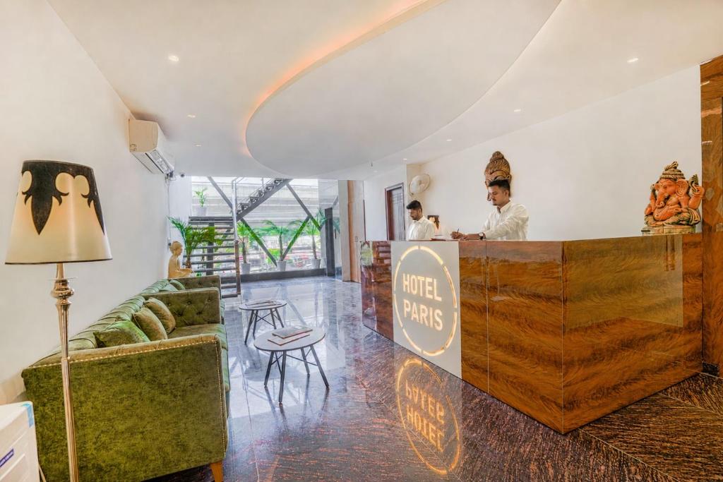 a restaurant with a counter with two men behind it at Hotel Paris Chandigarh Zirakpur in Zirakpur