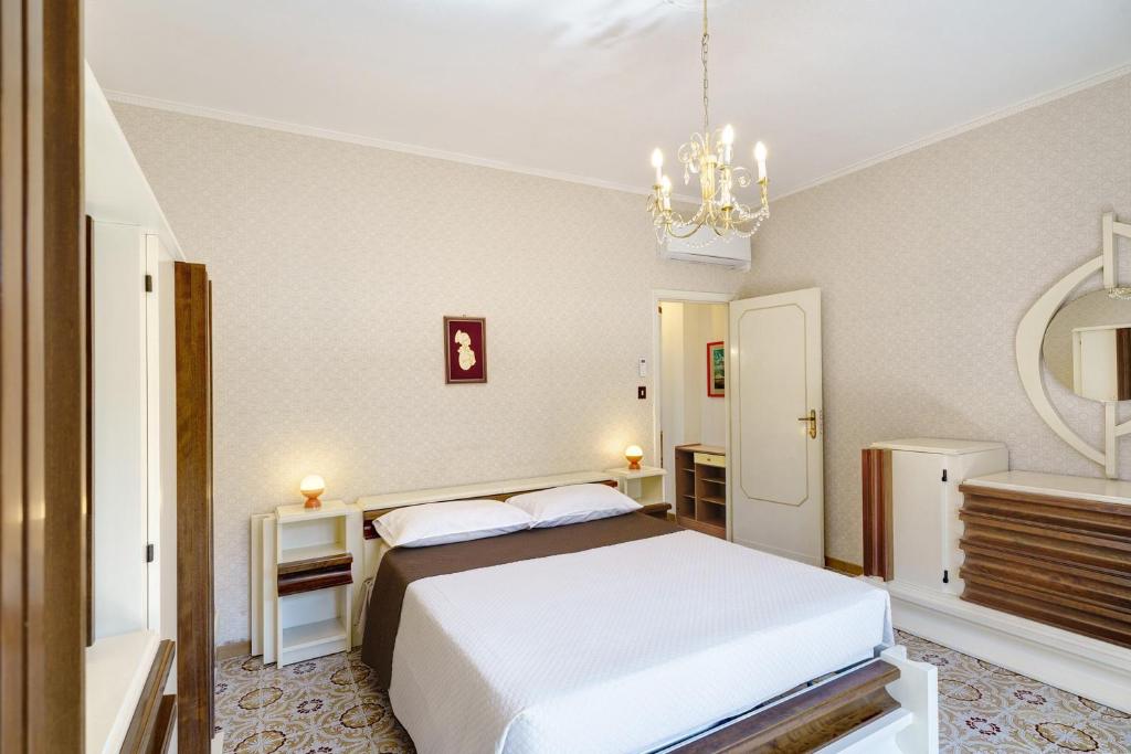 a bedroom with a white bed and a mirror at Seaside House in Paestum