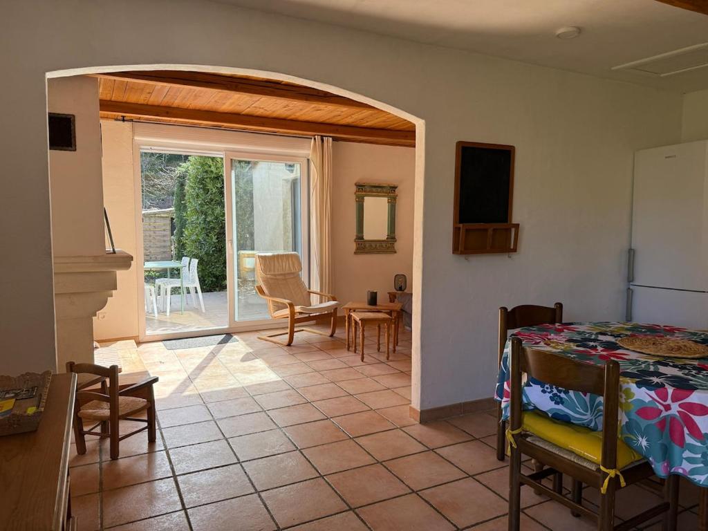 a living room with a table and a room with a view at Ma maisonnette en Cévennes in Le Vigan