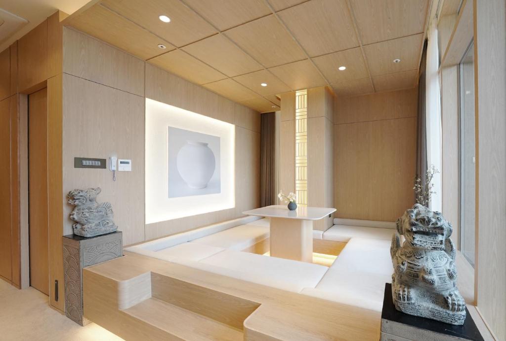a living room with a large white room with a table at UH Suite The Seolleung in Seoul