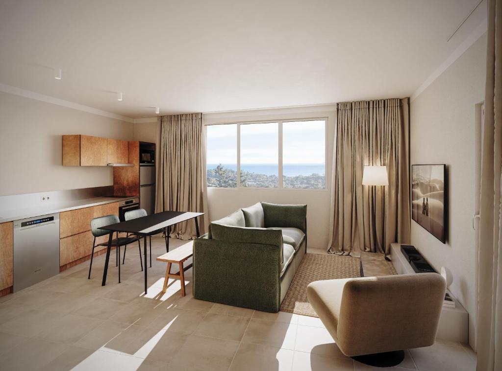 a living room with a couch and a table in a room at Versants - La Croix Valmer in La Croix-Valmer