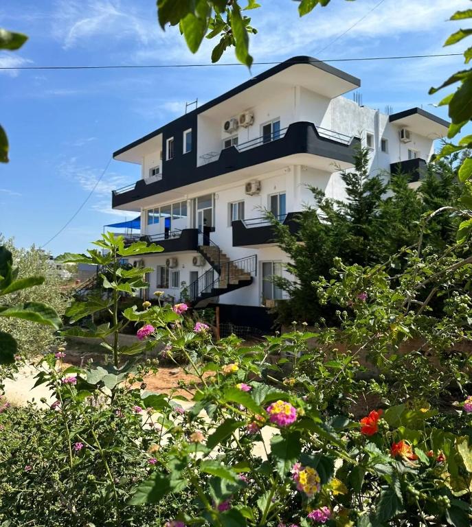 a building with flowers in front of it at Vila Familjare Memushi in Ksamil