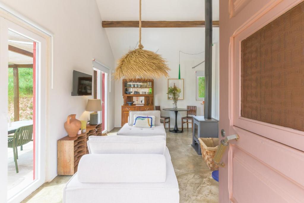 a living room with two beds and a table at Cozy Countryside Studio in Aldeia do Cano