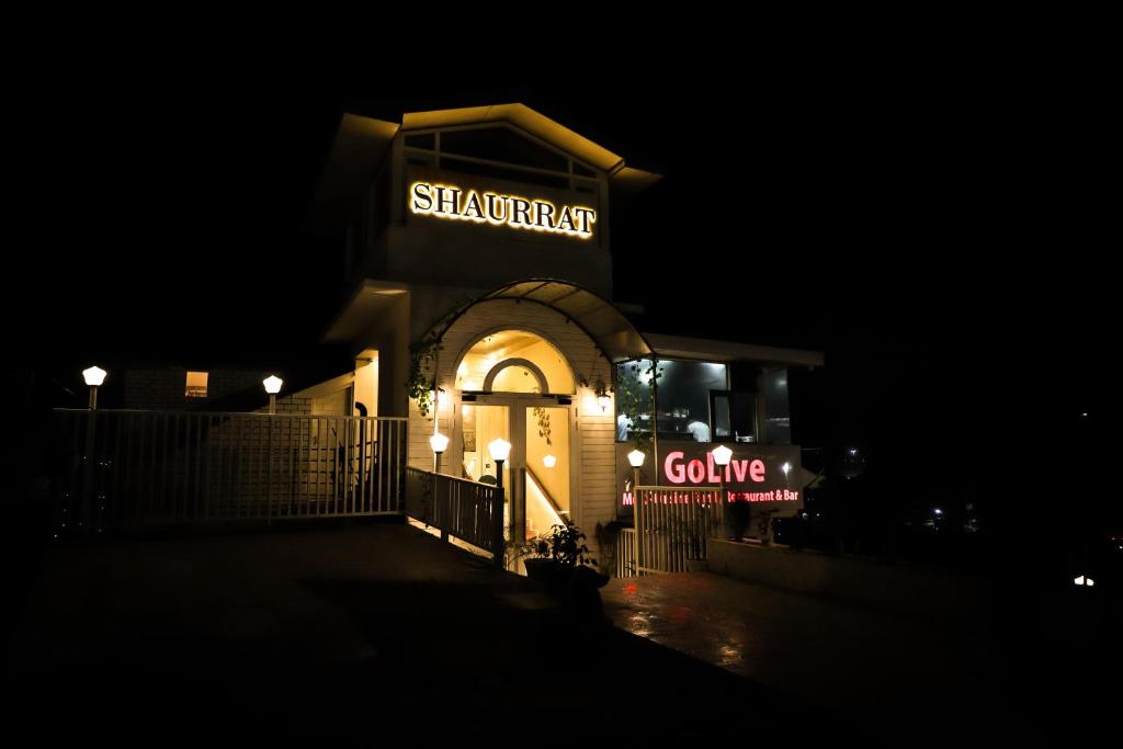 a shakespeare centre lit up at night at Hotel Shaurrat in Shimla