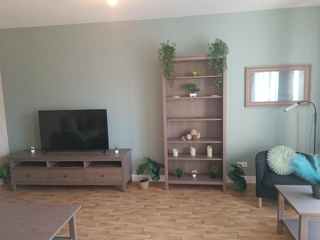 a living room with a flat screen tv on a shelf at Marmande in Marmande