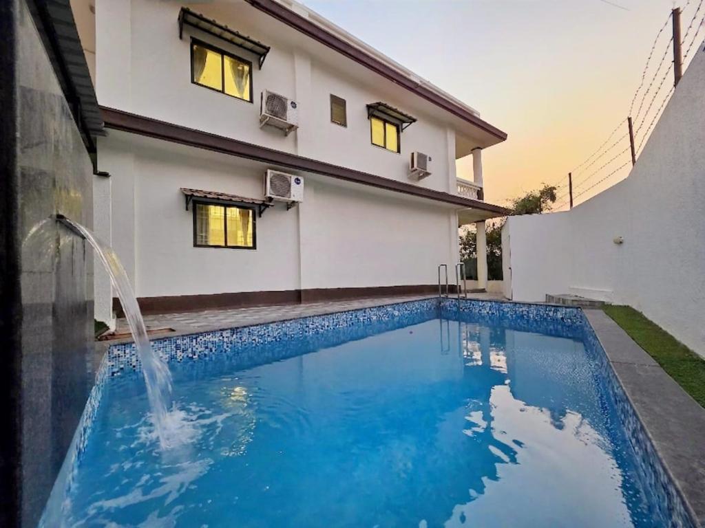 a swimming pool in front of a house at JAGUAR VILLA II 3BHK II AC II POOL Il EMPYREAN STAY in Lonavala
