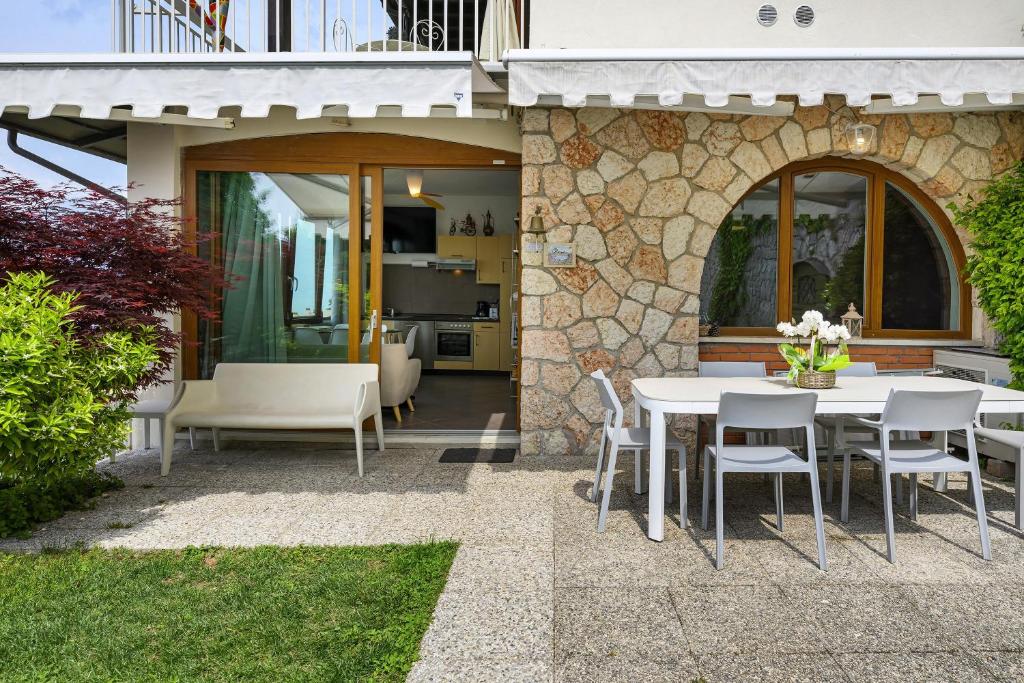 a patio with a table and chairs and a house at Residence La Mignon Oleandri in Torri del Benaco