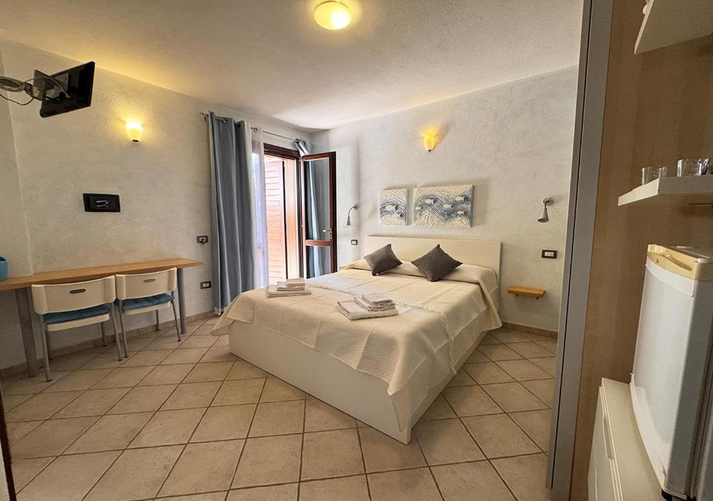 a bedroom with a bed and a table in it at Crisalide in La Maddalena